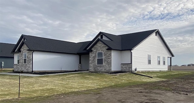 view of front of property featuring stone siding and a front lawn