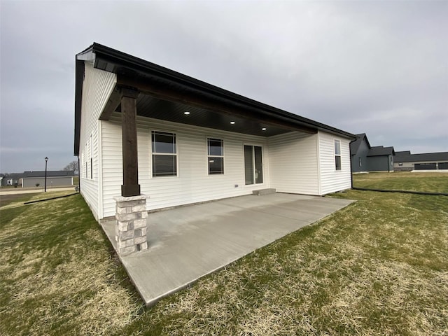 rear view of house featuring a patio area and a lawn