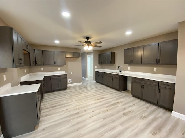 kitchen with recessed lighting, light wood-style floors, a sink, ceiling fan, and baseboards