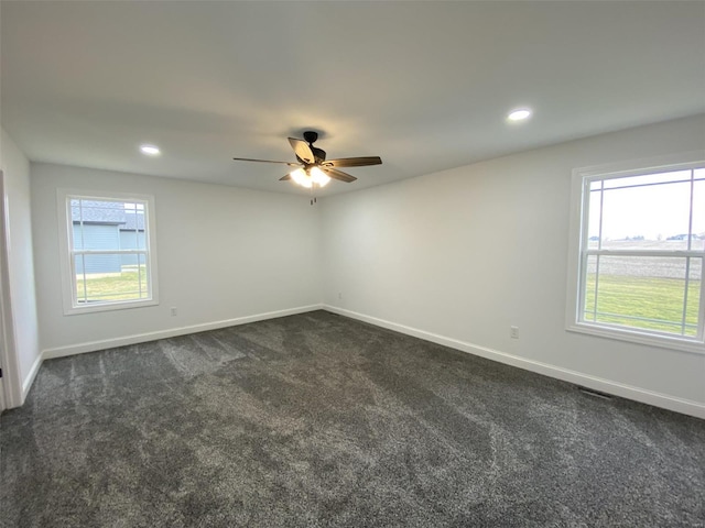 spare room featuring recessed lighting, dark carpet, and baseboards