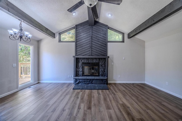 unfurnished living room featuring vaulted ceiling with beams, a fireplace, a textured ceiling, and wood finished floors