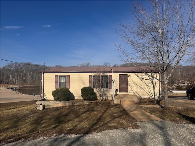 view of front of house with a front yard and metal roof