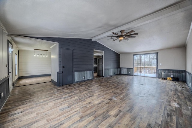 unfurnished living room featuring ceiling fan, lofted ceiling with beams, a textured ceiling, and wood finished floors