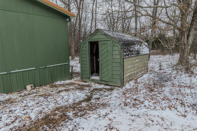 snow covered structure with an outdoor structure and a storage unit