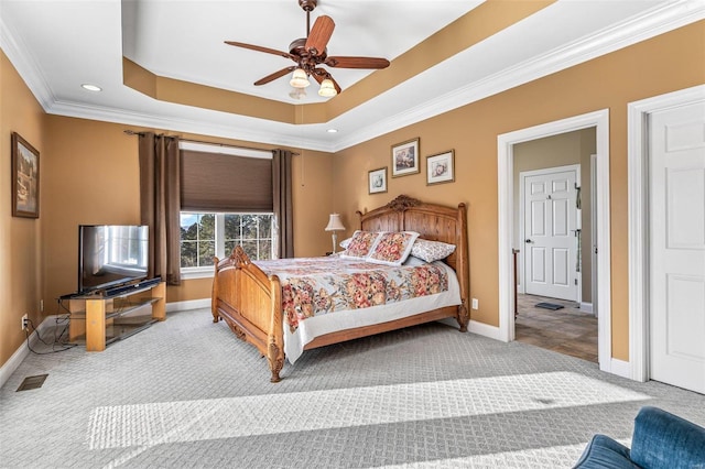 bedroom featuring baseboards, a raised ceiling, carpet floors, and ornamental molding