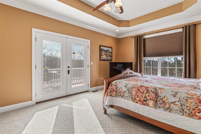 carpeted bedroom with baseboards, a tray ceiling, french doors, crown molding, and access to outside