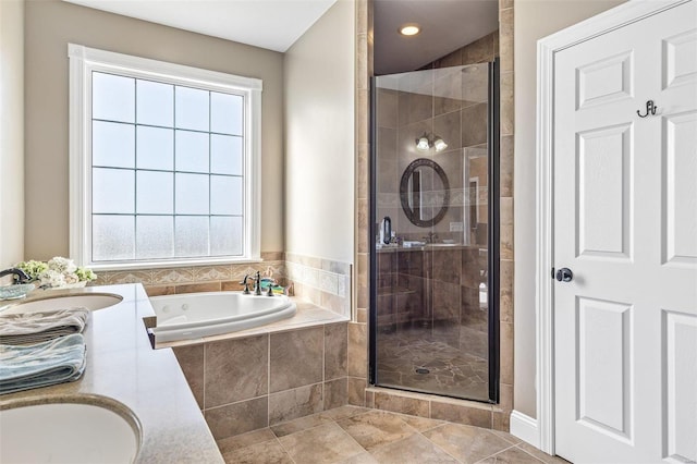 bathroom with a shower stall, a garden tub, and a sink