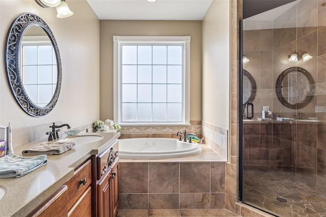 bathroom with a garden tub, a stall shower, and vanity