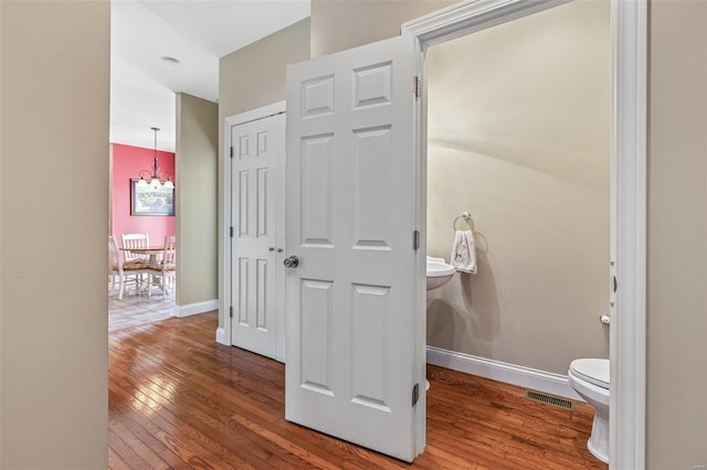 bathroom with toilet, baseboards, visible vents, and wood-type flooring