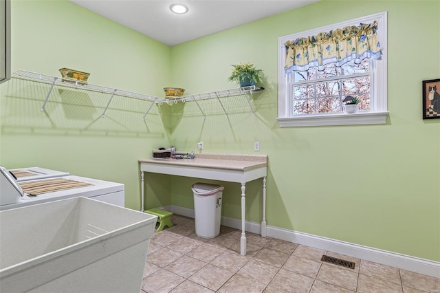 washroom featuring light tile patterned floors, baseboards, visible vents, laundry area, and washer and dryer