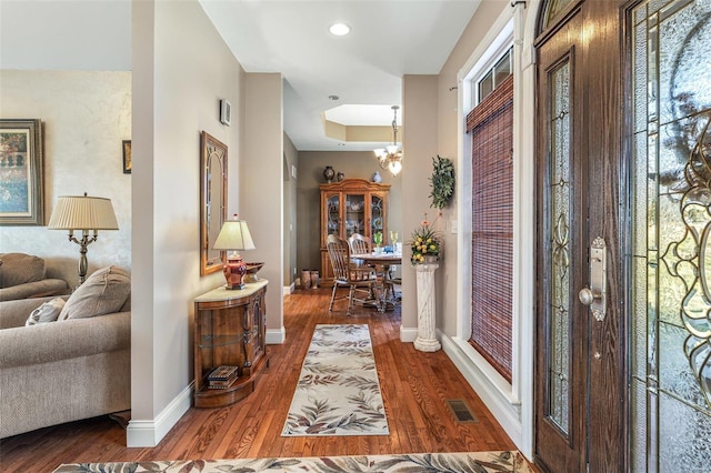 foyer featuring wood finished floors, visible vents, baseboards, recessed lighting, and a chandelier