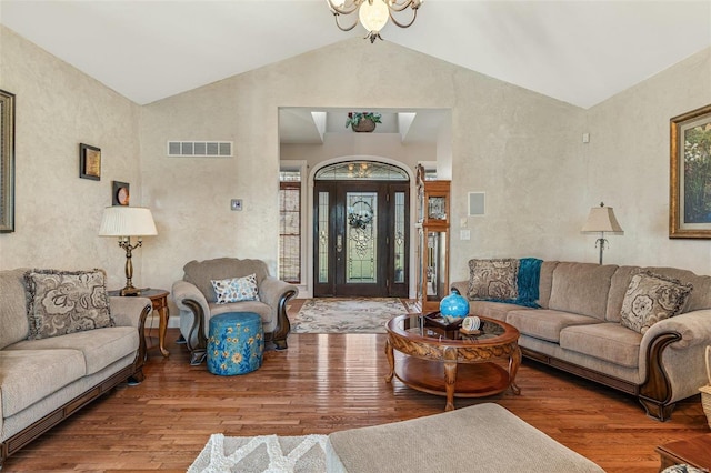 living area with wood finished floors, visible vents, and a chandelier