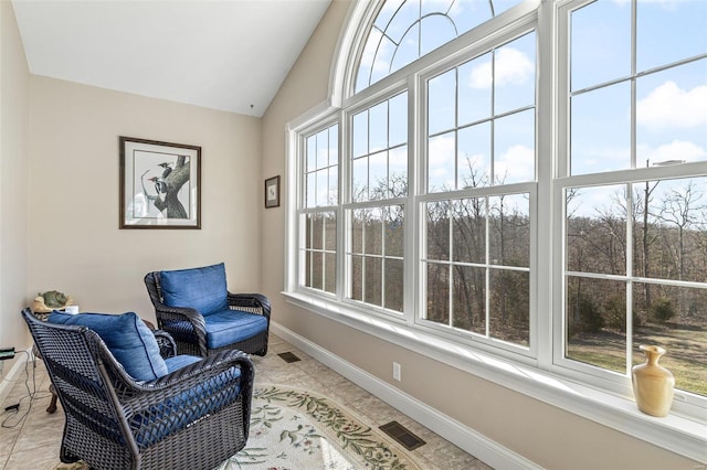 sitting room featuring visible vents, lofted ceiling, baseboards, and light tile patterned flooring