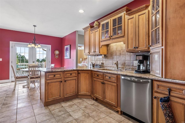 kitchen featuring backsplash, brown cabinets, a peninsula, stainless steel dishwasher, and a sink