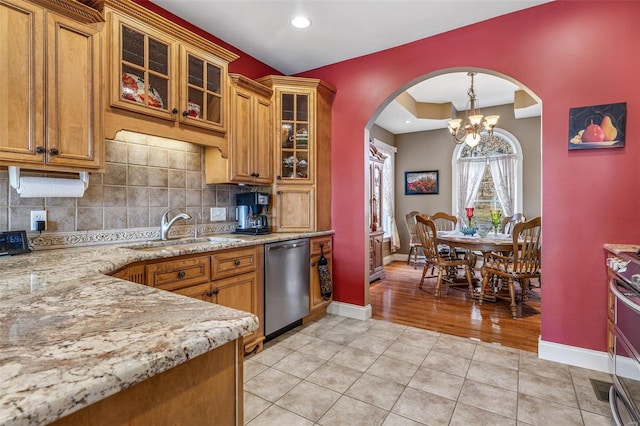 kitchen featuring a sink, brown cabinets, stainless steel dishwasher, and light tile patterned floors