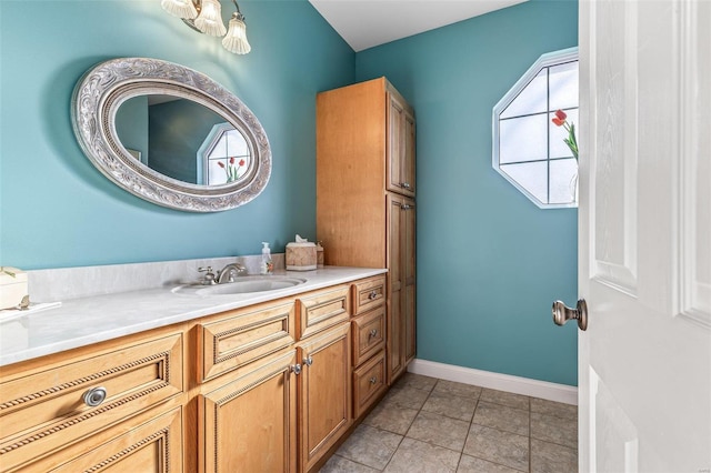 bathroom with baseboards, vanity, and tile patterned flooring