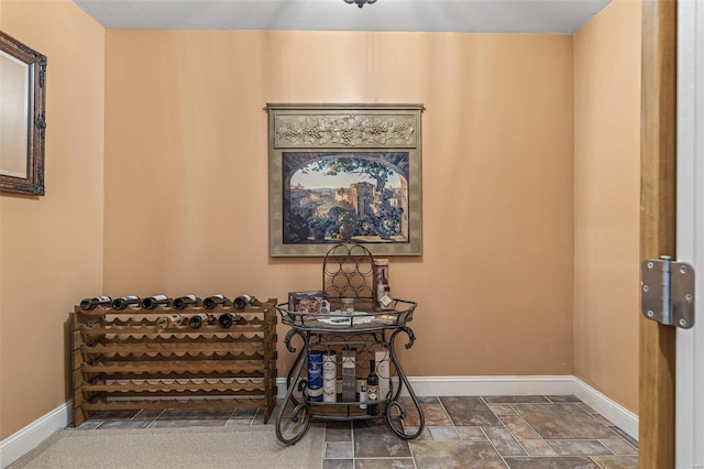 living area featuring baseboards and stone finish floor