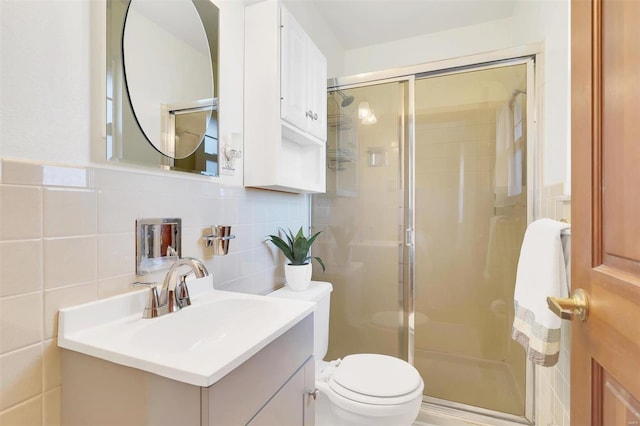 full bath featuring tile walls, a stall shower, toilet, and vanity