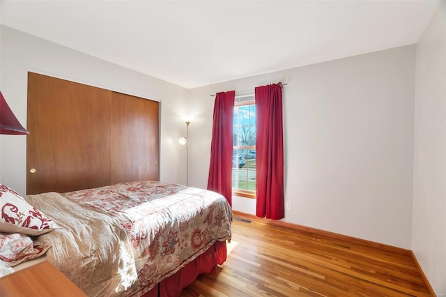 bedroom featuring visible vents, wood finished floors, and a closet