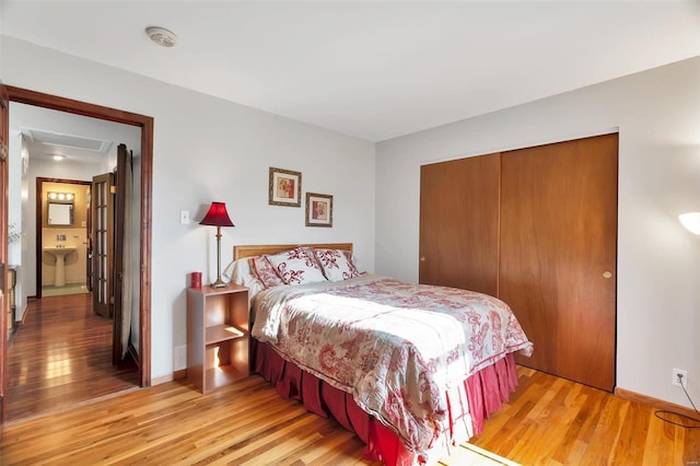 bedroom featuring a closet, baseboards, and light wood finished floors