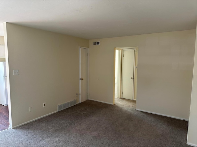 spare room featuring visible vents, baseboards, and carpet floors