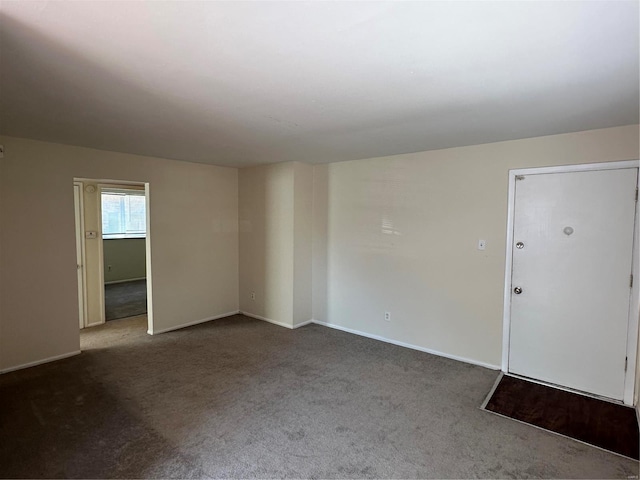 carpeted empty room featuring baseboards