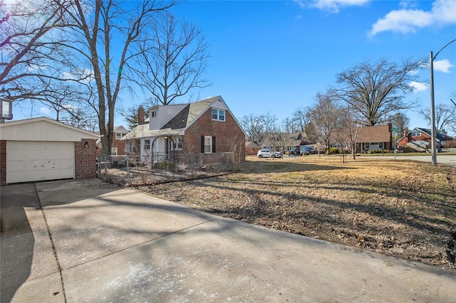 view of side of property featuring a residential view, brick siding, driveway, and fence