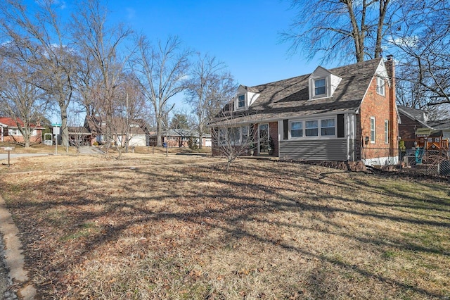 exterior space with a front yard, brick siding, and fence