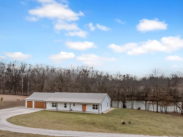 view of front of home featuring a porch, a garage, driveway, and a front yard