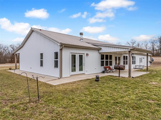 back of property featuring a patio, a yard, french doors, and metal roof