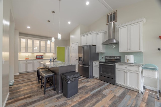 kitchen featuring a sink, stainless steel refrigerator with ice dispenser, white cabinetry, wall chimney exhaust hood, and black electric range oven