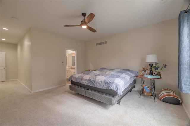 carpeted bedroom with visible vents, baseboards, ensuite bath, and ceiling fan