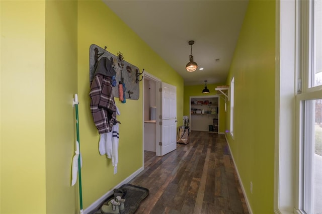 hallway with baseboards and dark wood-type flooring