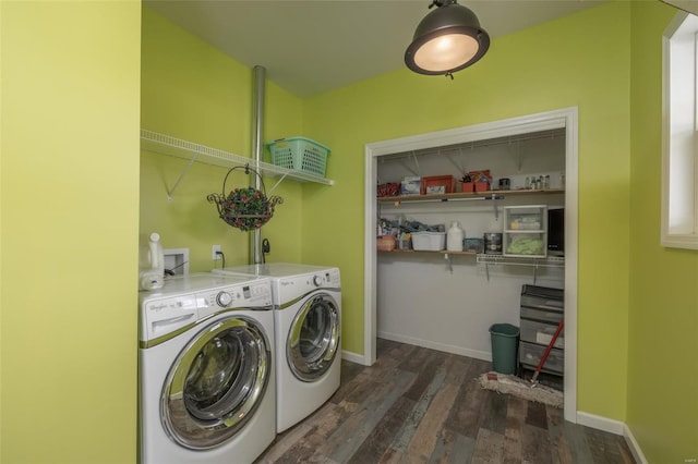 clothes washing area featuring laundry area, washing machine and dryer, dark wood-type flooring, and baseboards