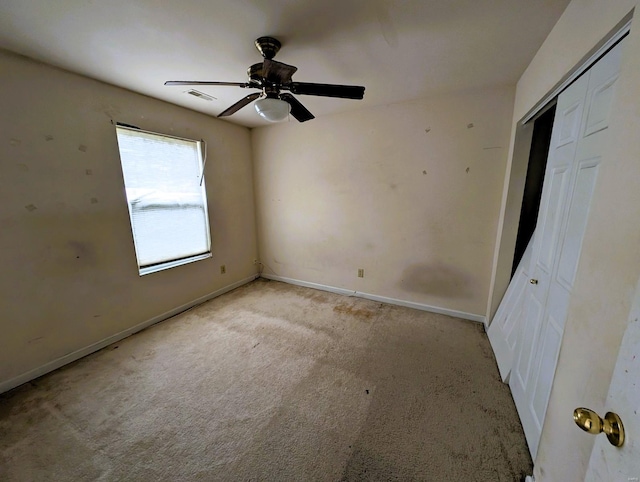 unfurnished bedroom with a closet, light colored carpet, visible vents, a ceiling fan, and baseboards