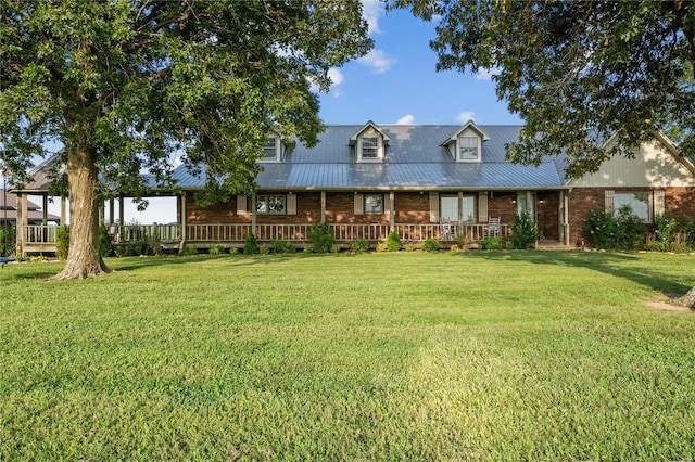 view of front facade with brick siding, metal roof, and a front lawn