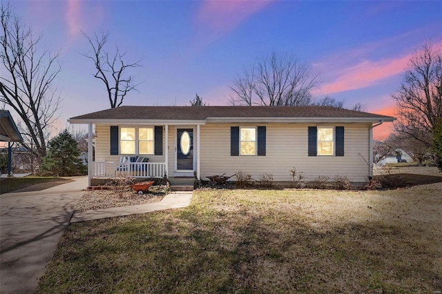 view of front of house with a porch, a front yard, and driveway