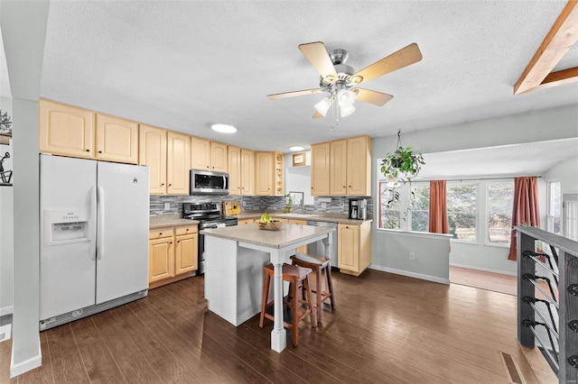 kitchen featuring dark wood finished floors, light countertops, tasteful backsplash, and appliances with stainless steel finishes