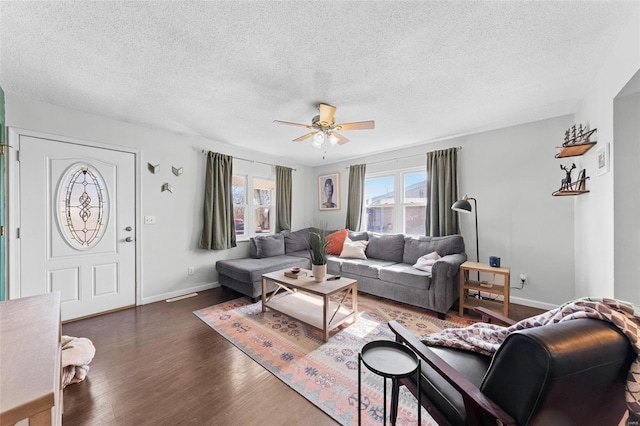 living room with a textured ceiling, baseboards, ceiling fan, and wood finished floors