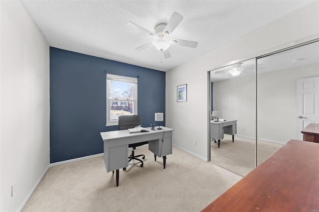 home office featuring baseboards, light carpet, a textured ceiling, and ceiling fan