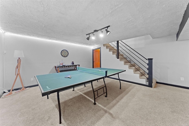 playroom with track lighting, a textured ceiling, baseboards, and carpet floors