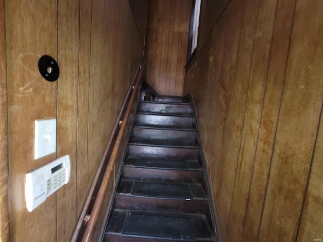 stairs featuring wood walls