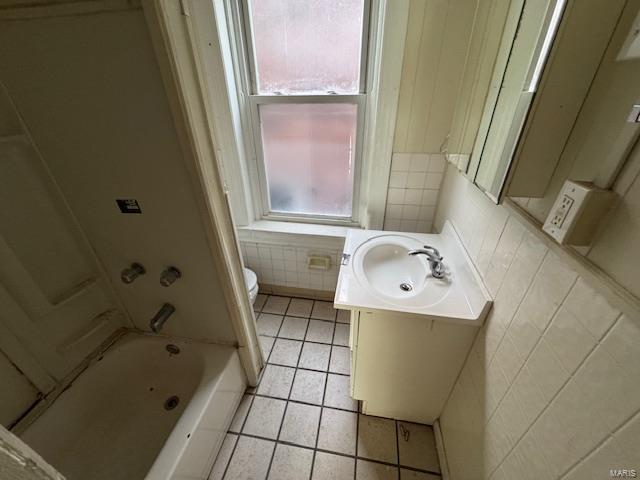 full bath with tile patterned flooring, toilet, tile walls, and vanity