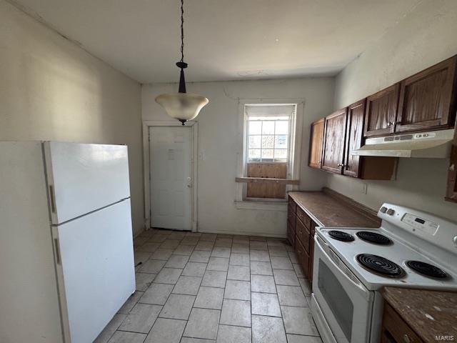 kitchen with white appliances, hanging light fixtures, and under cabinet range hood