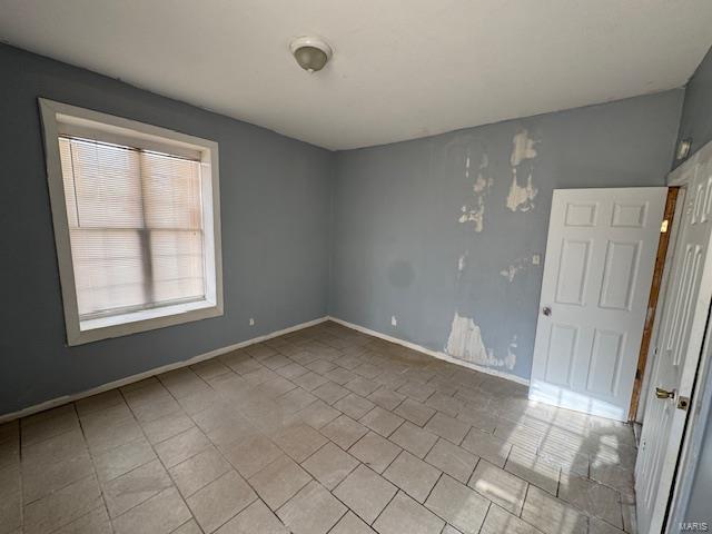 spare room featuring baseboards