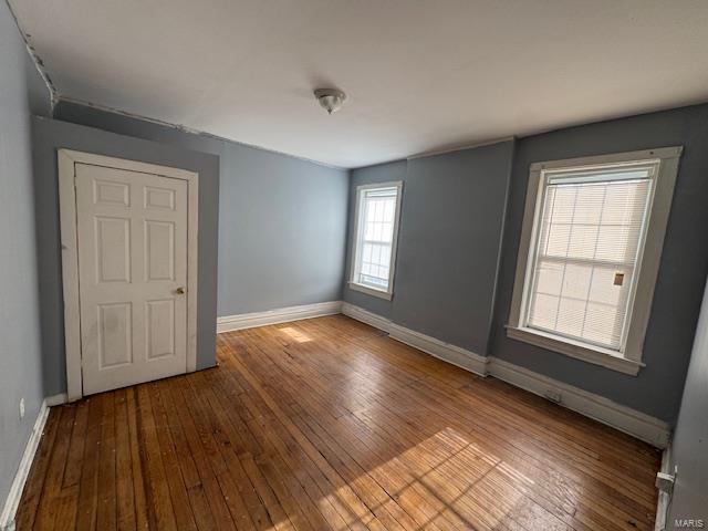 unfurnished bedroom with hardwood / wood-style floors and baseboards