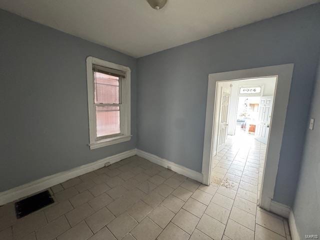 spare room with visible vents and baseboards