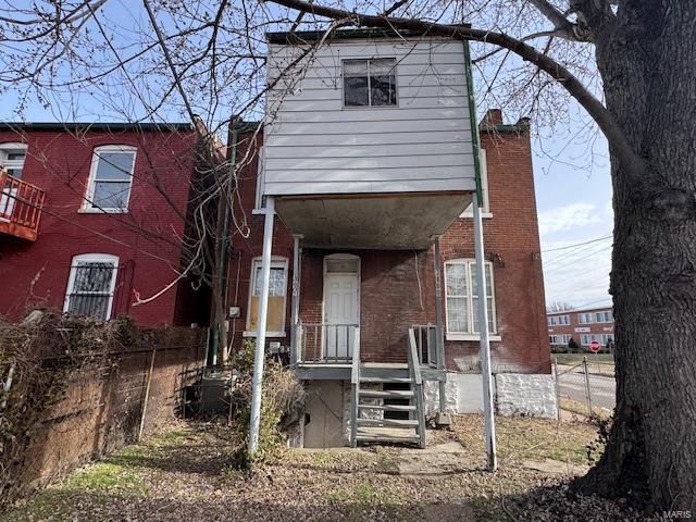 view of front of property featuring fence and brick siding