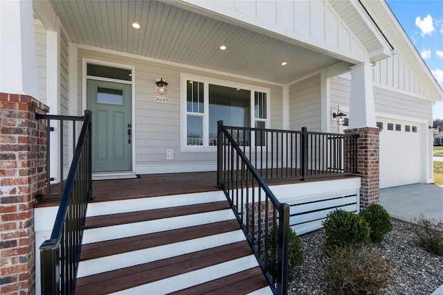 view of exterior entry featuring a porch, board and batten siding, driveway, and brick siding