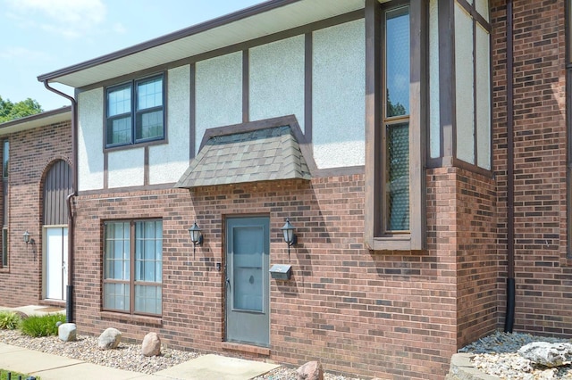 view of front of house featuring brick siding and stucco siding